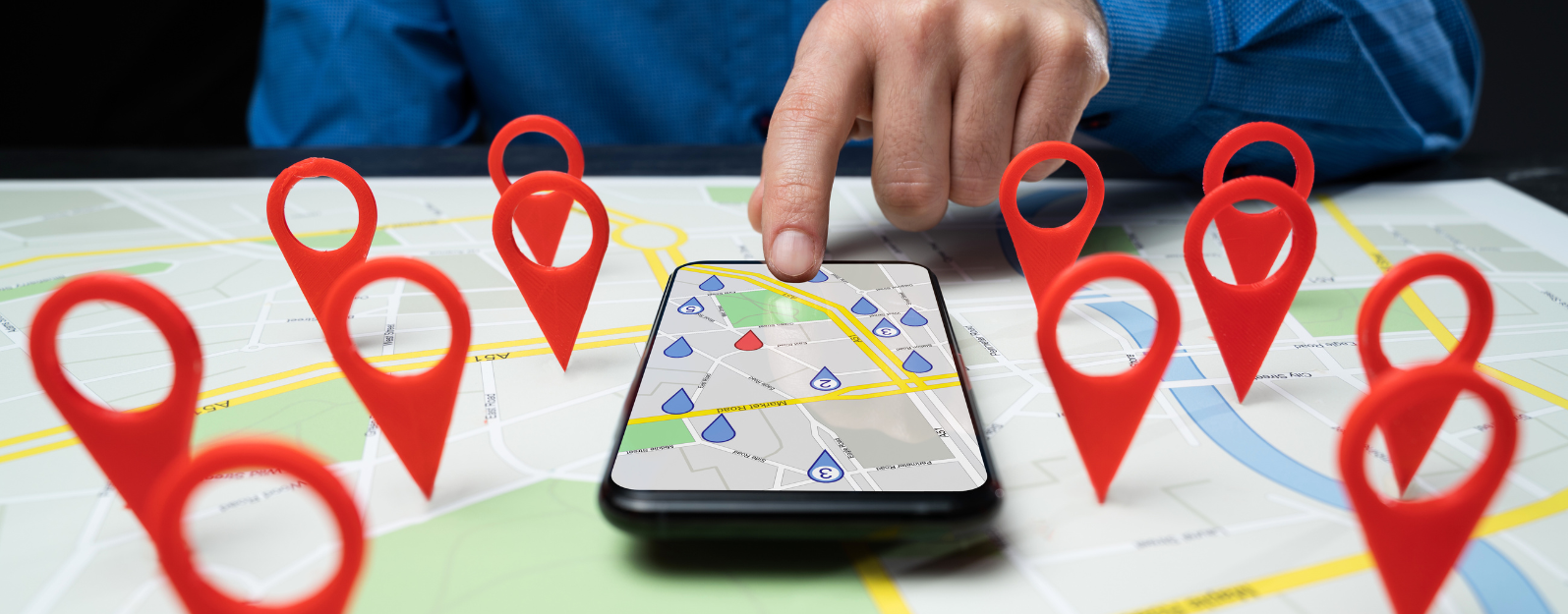 man pointing at a map on his phone with location pins alla round